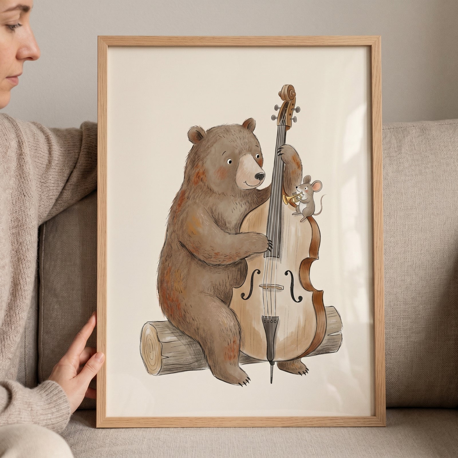 Framed whimsical cello playing bear wall art shows a brown bear and mouse playing music while sitting on a log.