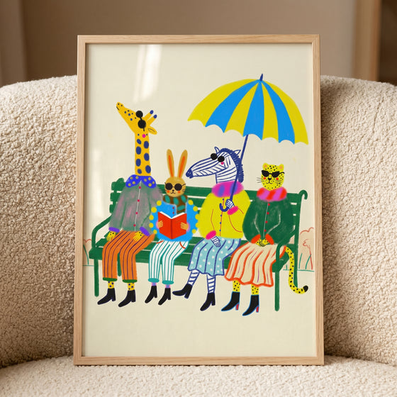 Whimsical dressed safari animals wall art featuring a giraffe, rabbit, zebra, and leopard sitting on a green park bench.