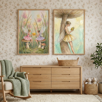 Two framed whimsical illustrations hang on a wall with a delicate floral pattern. The first illustration shows two sprites with delicate wings sitting on toadstools amidst tall grass, sharing a glowing orb. The second features a sprite leaning against a large toadstool stem while reading a book. Below the art is a light wood dresser with a wicker basket. To the left is a rocking chair with a green knit throw, and to the right is a potted plant and a basket of plush toys on a white rug.