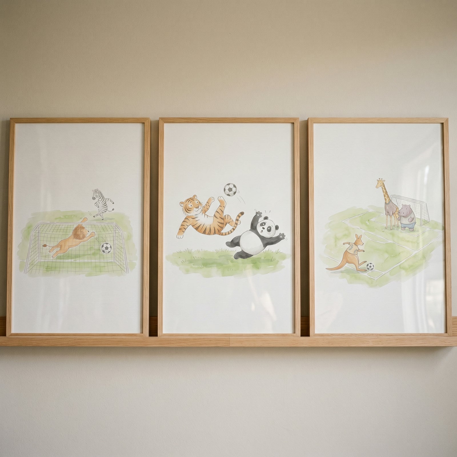 Whimsical football playing animals wall art set of 3, featuring watercolor animal illustrations in wooden frames.