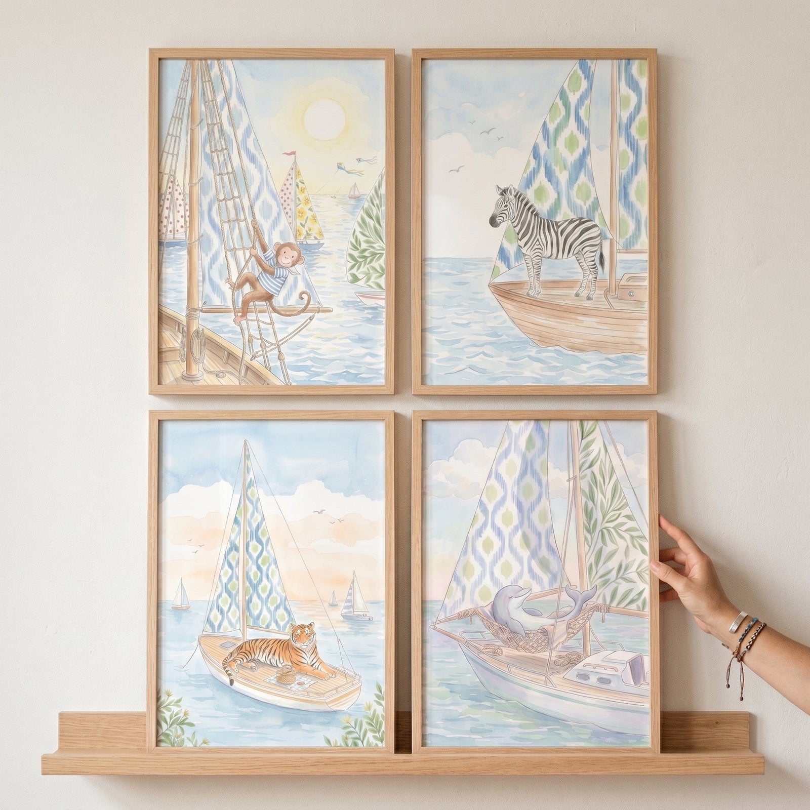 A hand touches a whimsical nautical animal wall art set of 4 showing a monkey, zebra, tiger, and dolphin on sailboats.