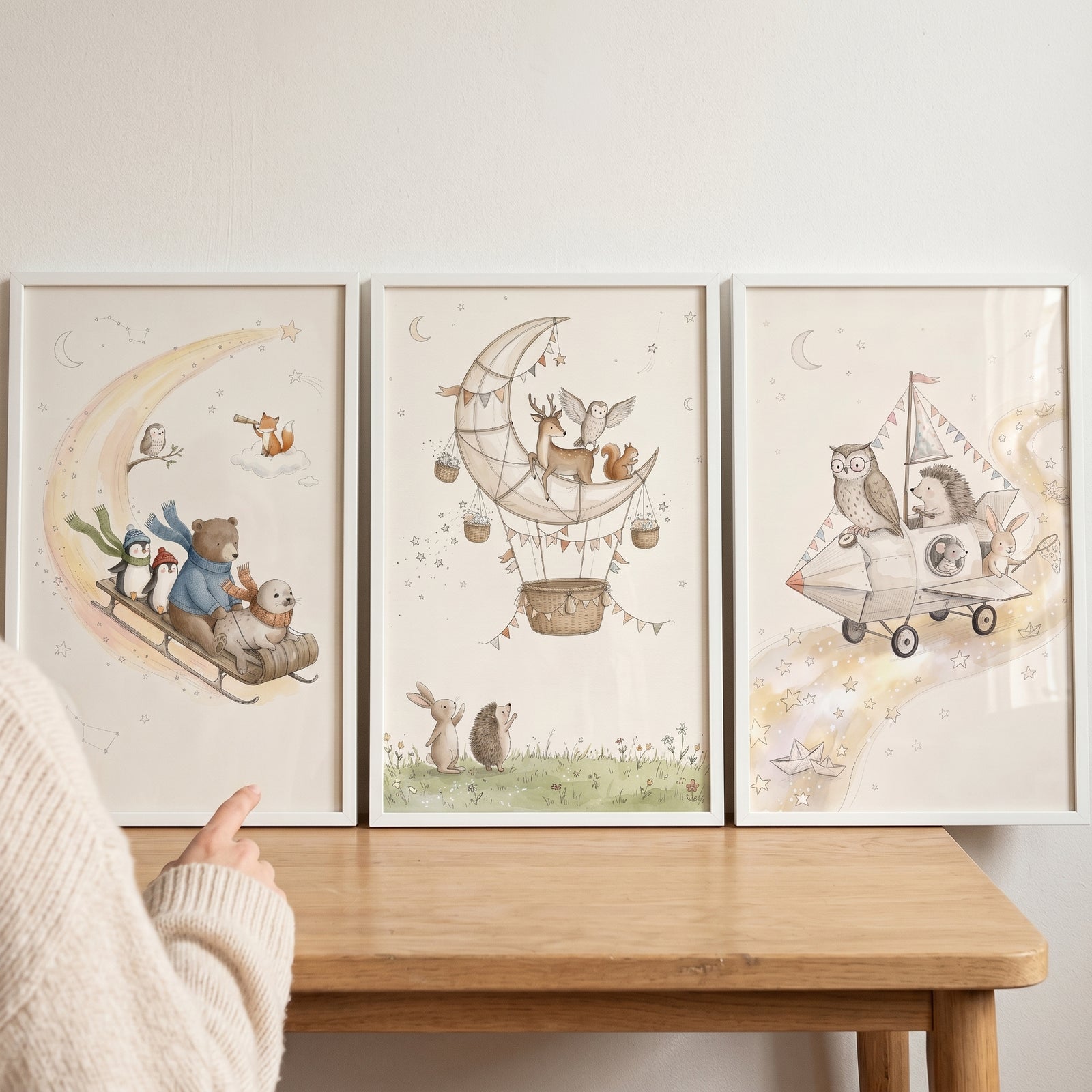 Whimsical neutral watercolor animals wall art set of 3 with creatures on a moon sled, hot air balloon, and plane.