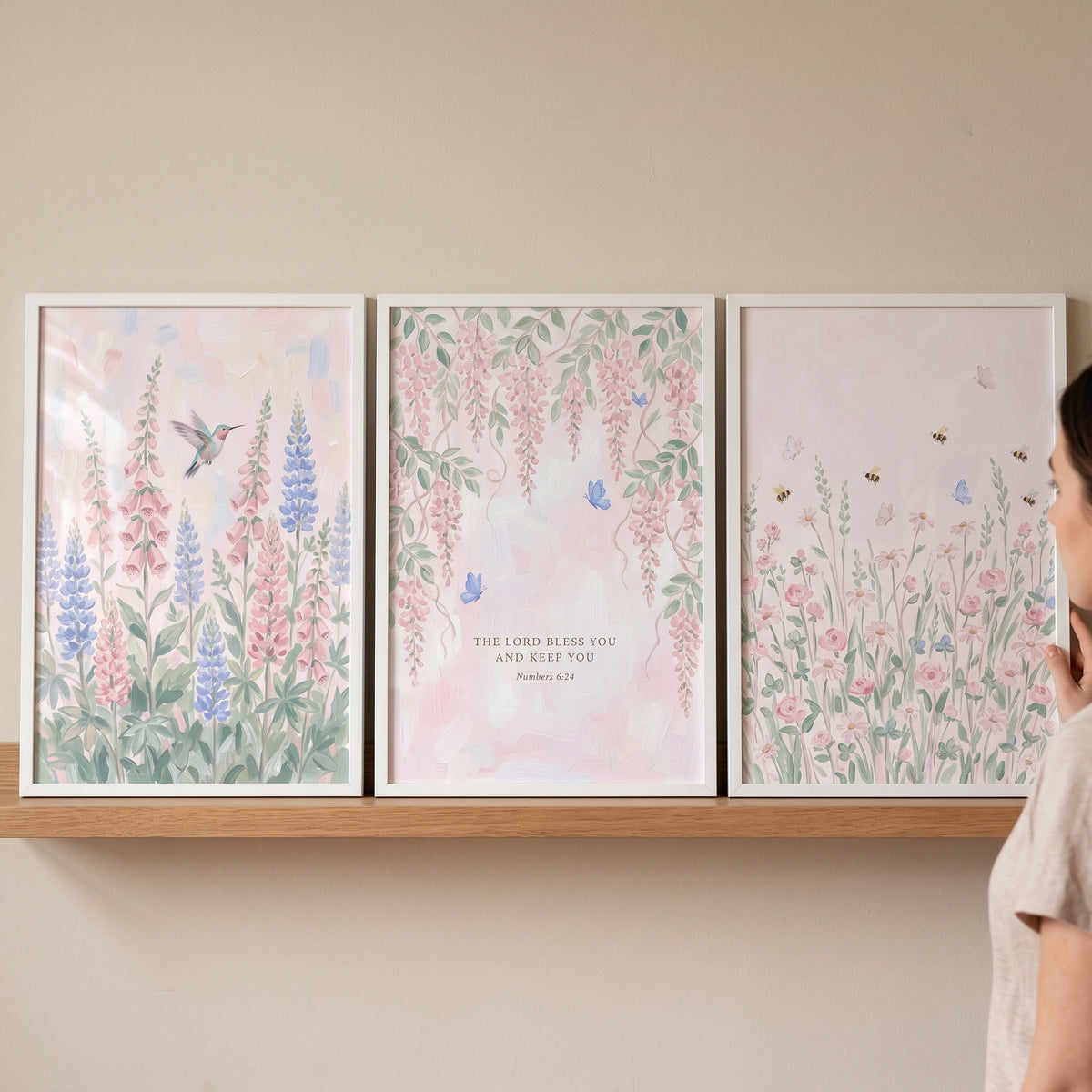 Whimsical pink botanical garden wall art set of 3 featuring flowers, a bird, and scripture on a wooden shelf.