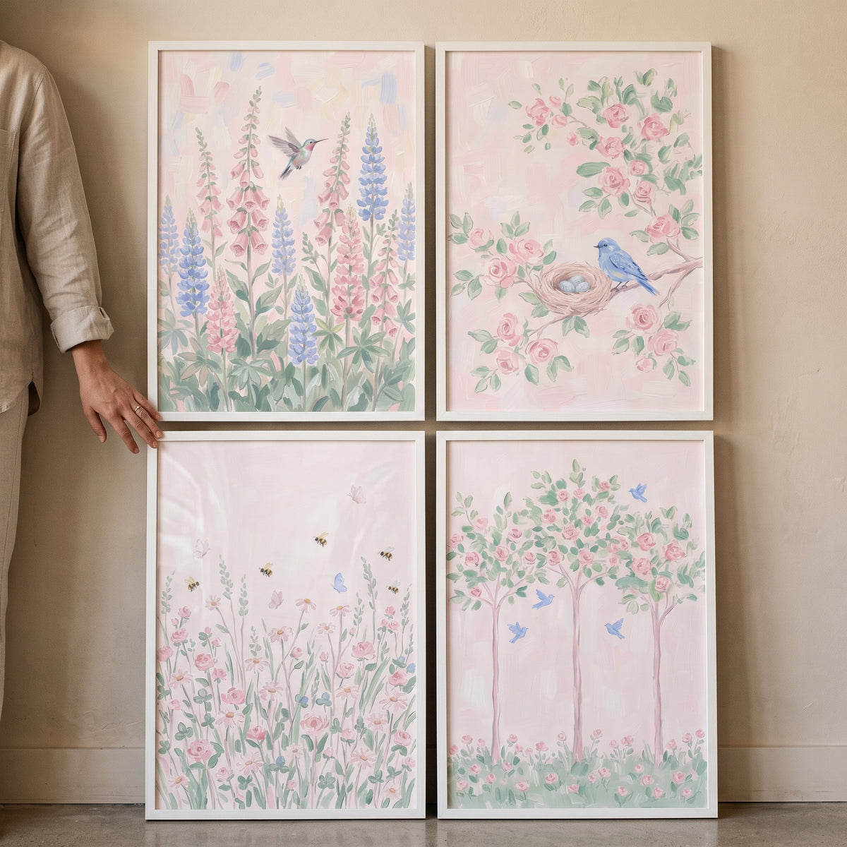 Whimsical pink meadow wall art set of 4 featuring birds, bees, and flowers in soft pastel colors on a neutral wall.