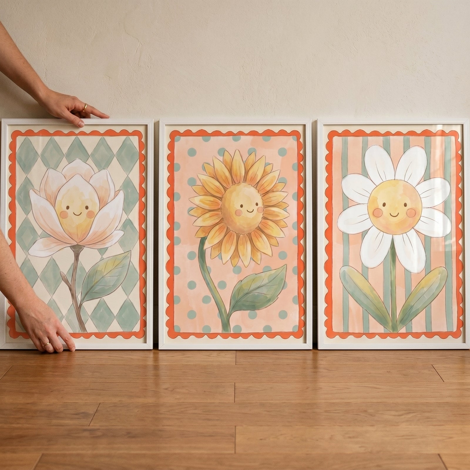 A hand touches a whimsical smiling flower wall art set of 3 featuring cute floral characters and scalloped orange borders.