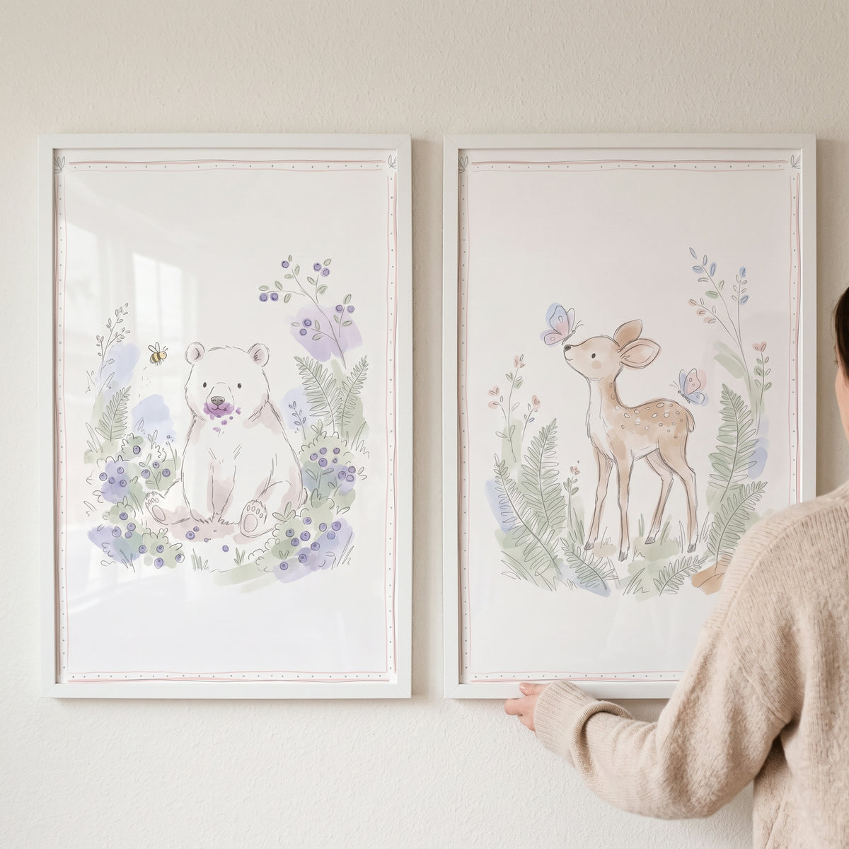 Whimsical storybook forest animal wall art set of 2 featuring a watercolor bear and deer in white frames on a wall.