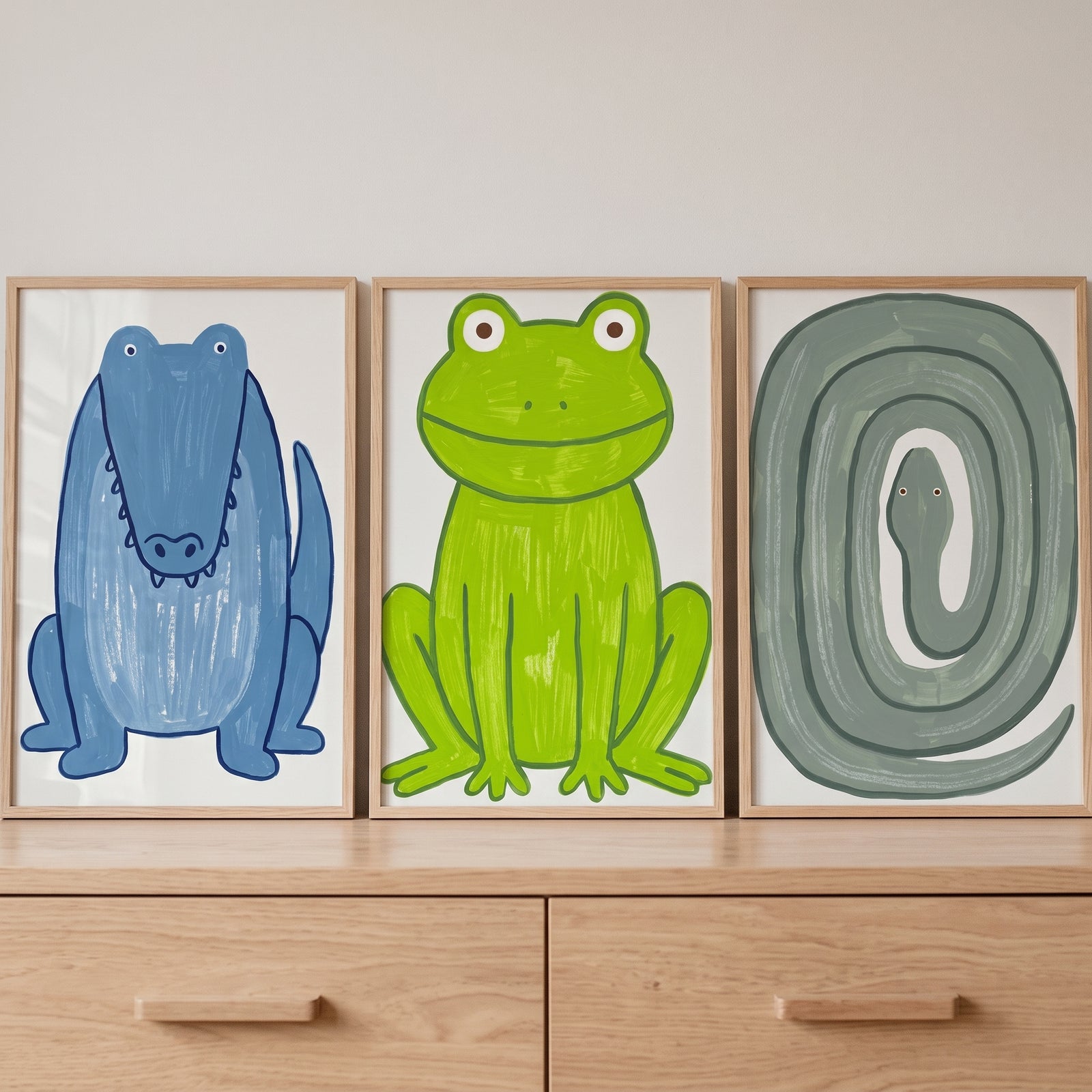 Whimsical textured animals wall art set of 3 featuring a blue crocodile, green frog, and gray snake on a wooden dresser.