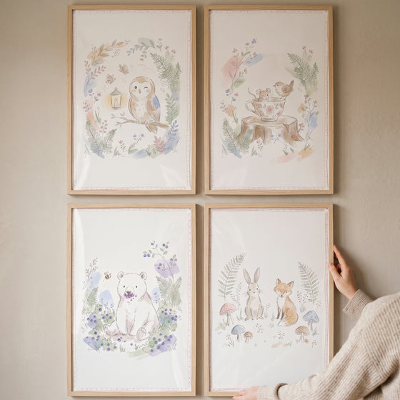 Whimsical watercolor forest creature wall art set of 4 featuring an owl, bear, bunny, and fox in a wood frame.