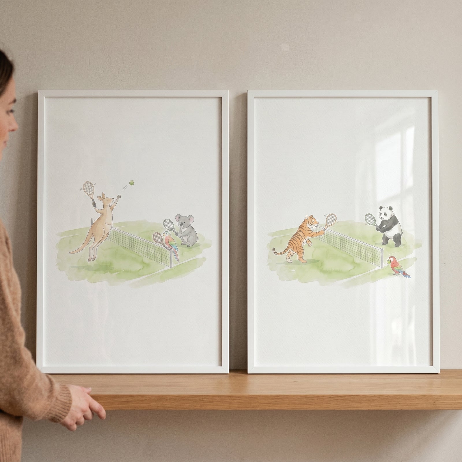 Whimsical watercolor tennis animals wall art set of 2 with a kangaroo, koala, tiger, and panda in white frames on a shelf.