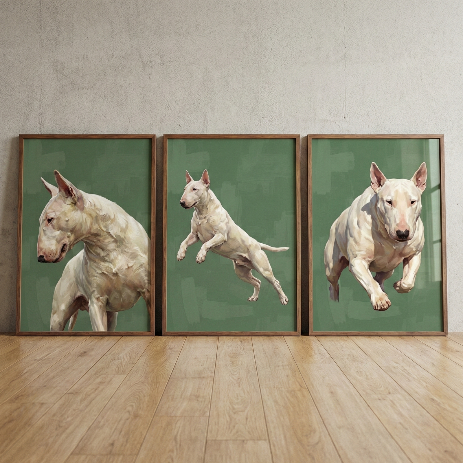 Three wood-framed artworks lean against a light gray wall on a polished wooden floor. Each piece features a white Bull Terrier against a solid olive green background with textured strokes. The left artwork shows a side profile of the dog's head and shoulders. The center artwork depicts the dog mid-leap from the side. The right artwork shows the dog running forward towards the viewer. The illustrative style highlights the breed's distinctive egg-shaped head and muscular physique.