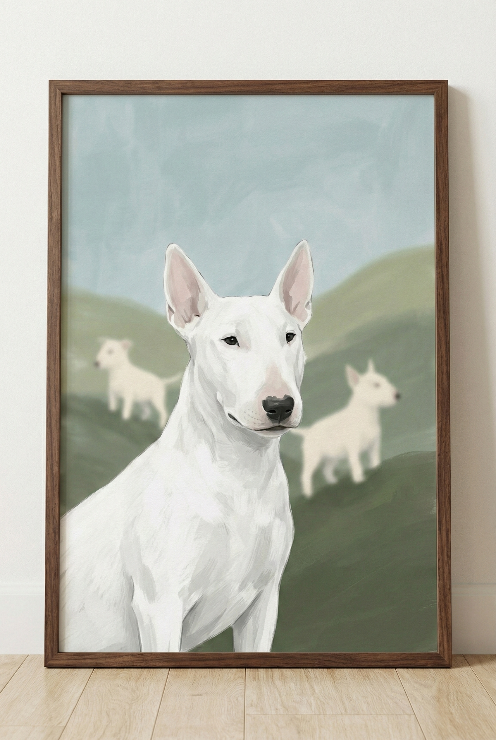 A framed digital illustration features three white Bull Terriers against a soft landscape. In the foreground, a large dog is depicted from the chest up, showcasing its unique head shape, small dark eyes, and upright ears. The texture of its white fur is rendered with visible digital brushstrokes. In the hazy background, two smaller versions of the dog stand on rolling green hills beneath a pale blue sky. The artwork is enclosed in a simple dark wood frame.