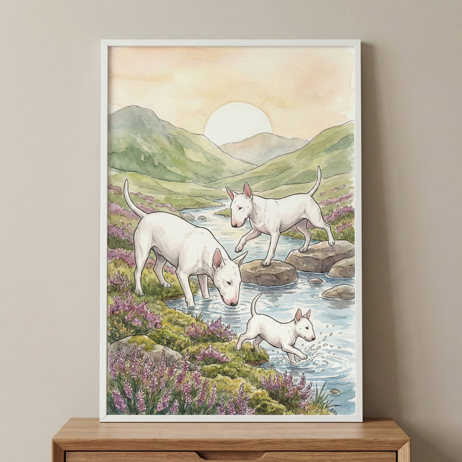 A vertical framed illustration featuring three white Bull Terrier-type dogs in a tranquil outdoor setting. The scene portrays two adult dogs and a smaller puppy near a flowing stream. One adult dog is bent down, drinking from the water, while the second adult dog walks across a series of large, flat rocks in the stream. A small puppy is captured in a playful pose, splashing in the water's edge. 