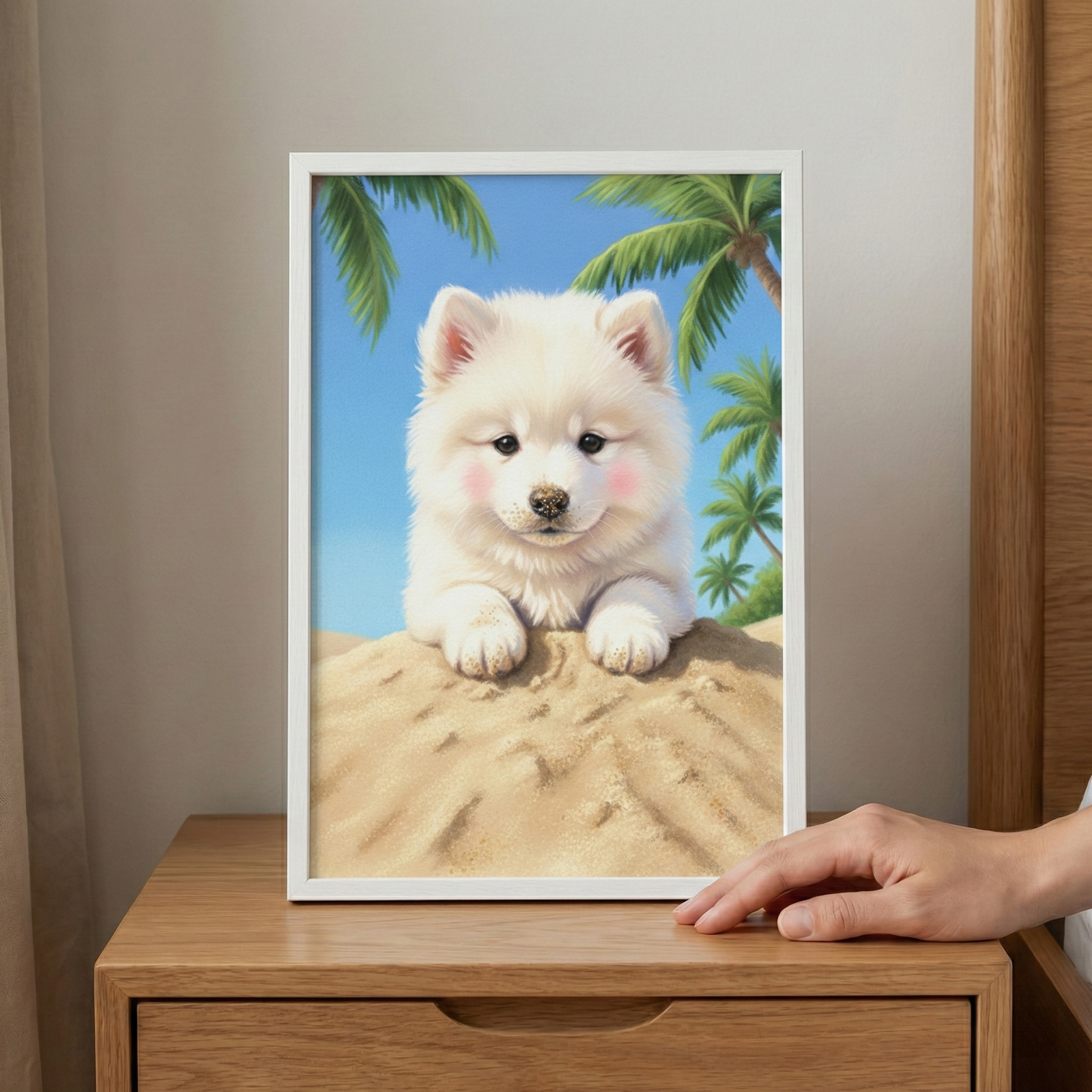 A white frame sits on a light wooden nightstand, being touched by a hand at the bottom corner. Inside the frame is an illustration of a fluffy, white puppy with rosy pink cheeks peering over a sandy hill. Behind the puppy are green palm trees and a clear blue sky, creating a tropical atmosphere.