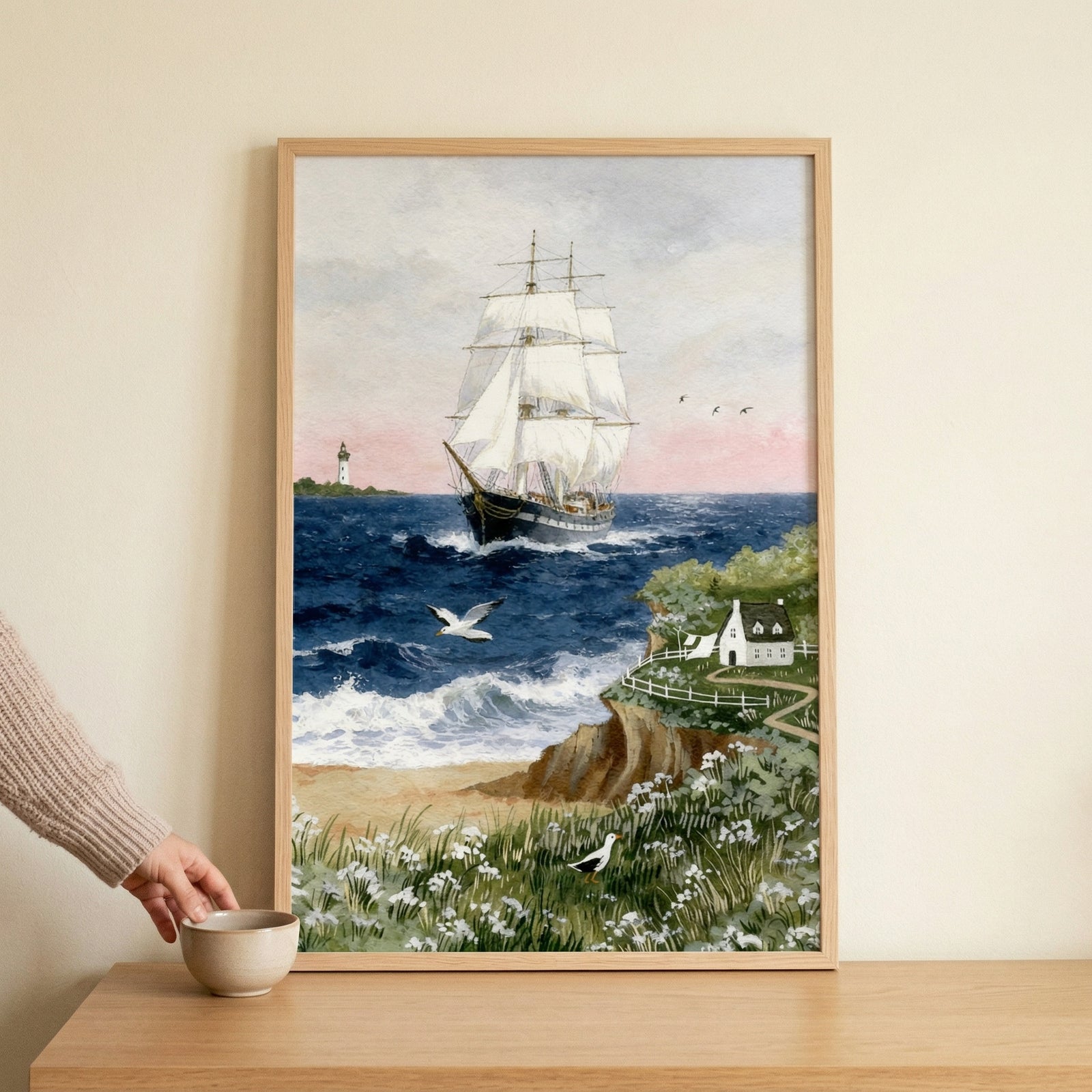 A whimsical watercolor illustration depicting a majestic three-masted sailing vessel with billowing white sails moving across a deep blue ocean. The view is from a verdant coastal cliffside filled with patches of small white flowers. 