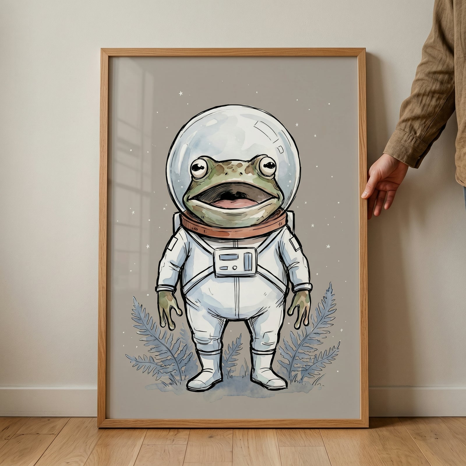 Framed white space suit frog wall art featuring a cartoon frog astronaut in a helmet against a starry background.