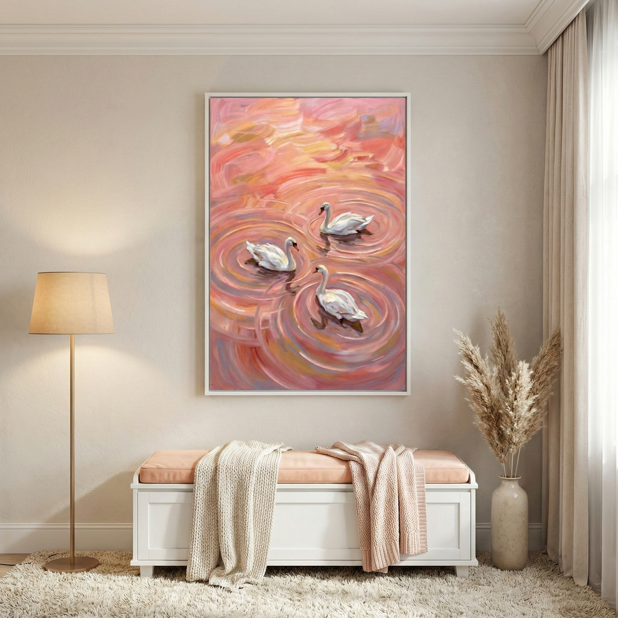 An elegant room setting showcases a framed canvas of three white swans swimming in vibrant pink water. The illustration uses bold, textured brushwork to create swirling patterns and ripples in hues of peach and rose. Beneath the wall art, a white wooden bench is accented with a pink cushion and cozy blankets. A tall floor lamp with a neutral shade and a vase of dried pampas grass complete the calm atmosphere, all set against a light beige wall and a plush cream rug.