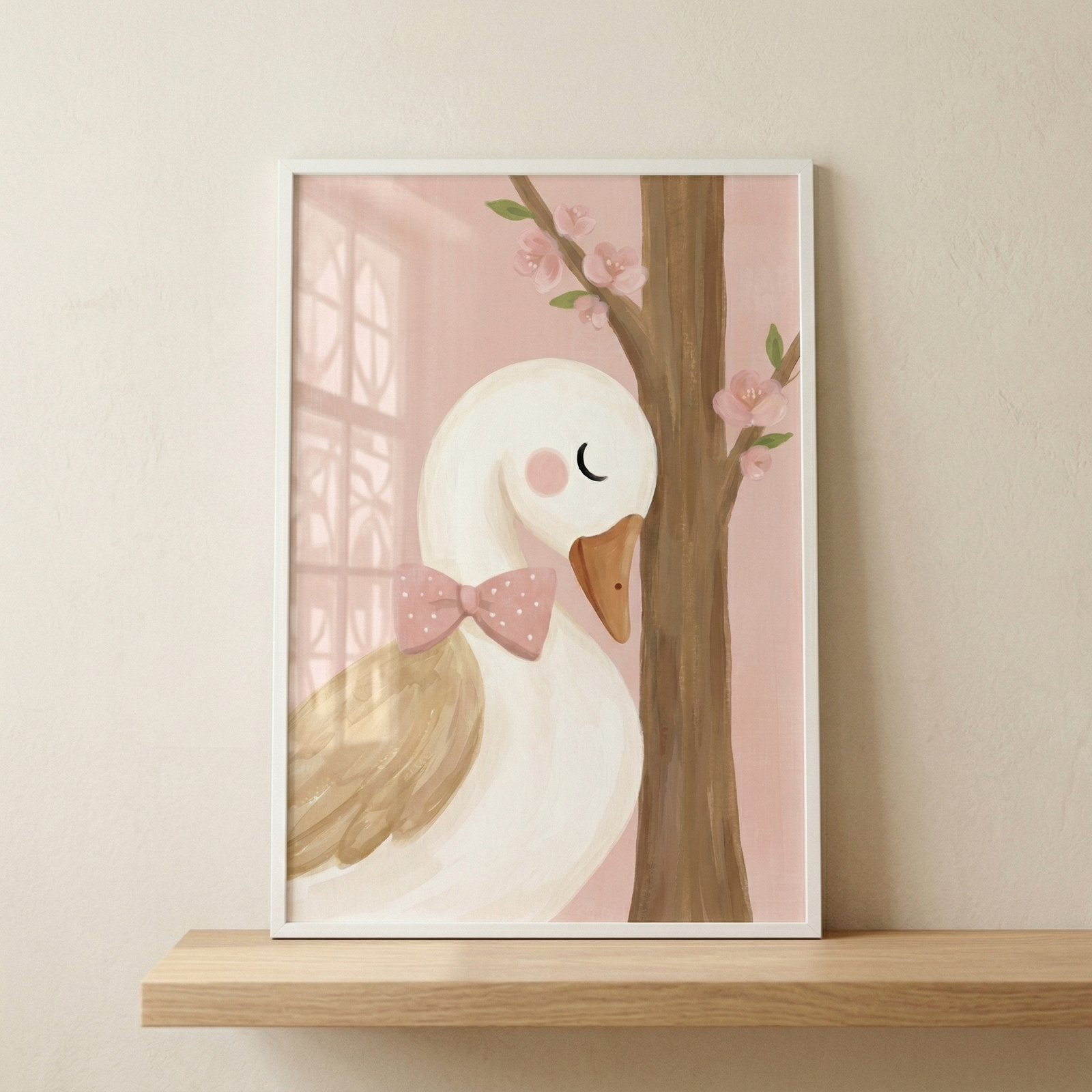 An illustrative print of a charming white goose is displayed in a white frame on a wooden shelf. The goose features soft tan wings, a bright orange beak, and a pink polka-dot bow tie around its neck. It has a peaceful expression with a closed eye and a rosy cheek. The background is a gentle pink, accented with a subtle window motif and a blooming tree trunk with delicate pink flowers and green leaves. This sweet piece of wall art exudes a calm, whimsical feel.