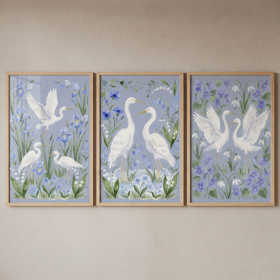 wildflower garden white egret bird wall art set of 3 features white birds among blue and purple flowers in wood frames.