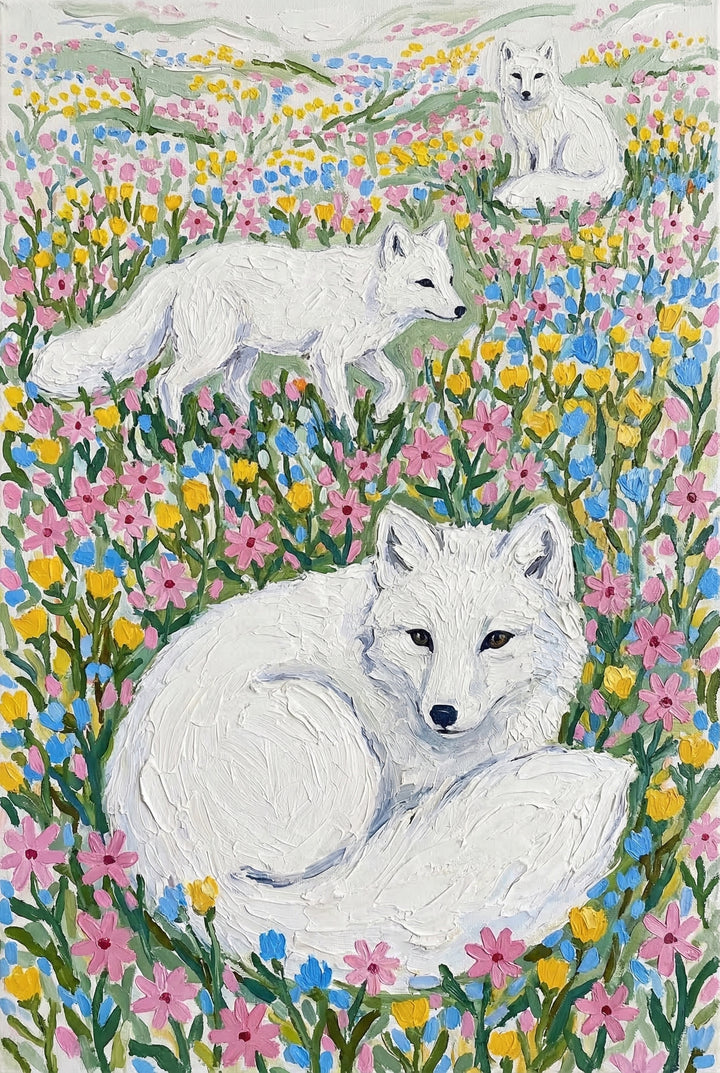 Three white foxes are nestled within a vibrant field of pink, yellow, and blue wildflowers in this textured artwork. In the foreground, a large fox is curled up, looking forward with dark, expressive eyes. Above it, another fox walks across the meadow, while a third sits alert in the distant background near rolling hills. The scene is rendered with thick impasto strokes that give the animals' fur and the surrounding flora a tactile, three-dimensional quality against a pale sky.