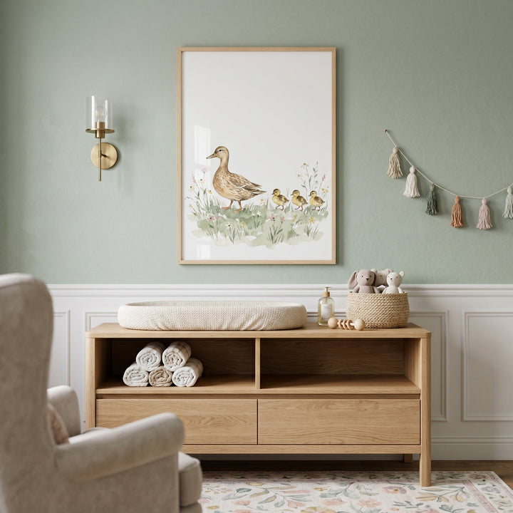 Sage green nursery featuring wildflower meadow nature duck wall art above a light wood dresser with a changing pad.