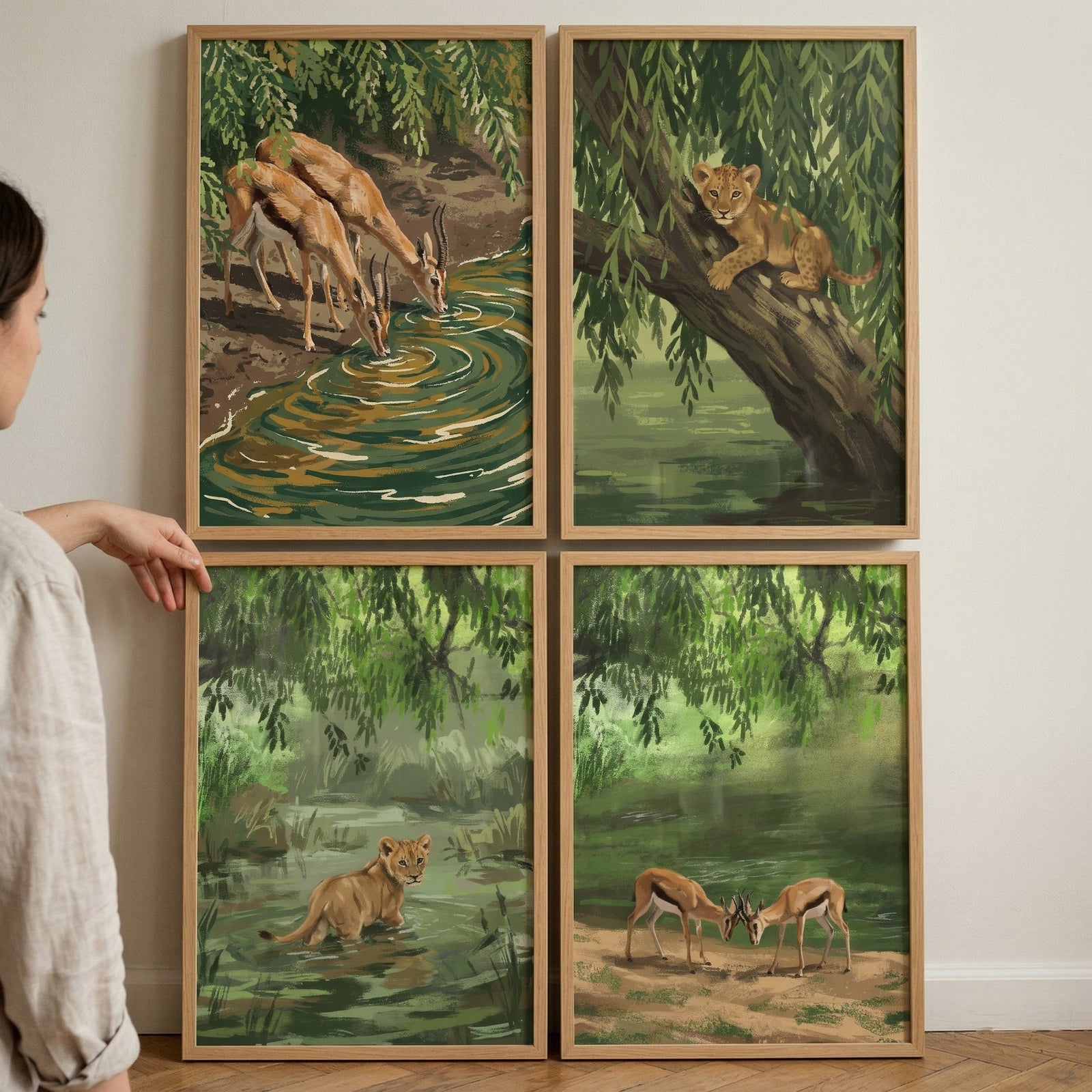 Willow canopy safari animal wall art set of 4 shows gazelles and lion cubs in lush green scenery near calm water.