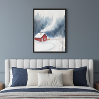 Bedroom with a white upholstered bed and blue and cream pillows. A framed watercolor painting of a red cabin in a snowy forest with smoke from the chimney hangs centered above the bed.