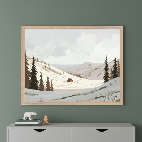 Framed artwork depicting a cozy cabin in a snowy mountain landscape, surrounded by evergreen trees under a cloudy sky. The illustration is styled with soft, muted colors and hangs on a green wall above a dresser decorated with a polar bear figurine, stacked books, and a small wooden tree.