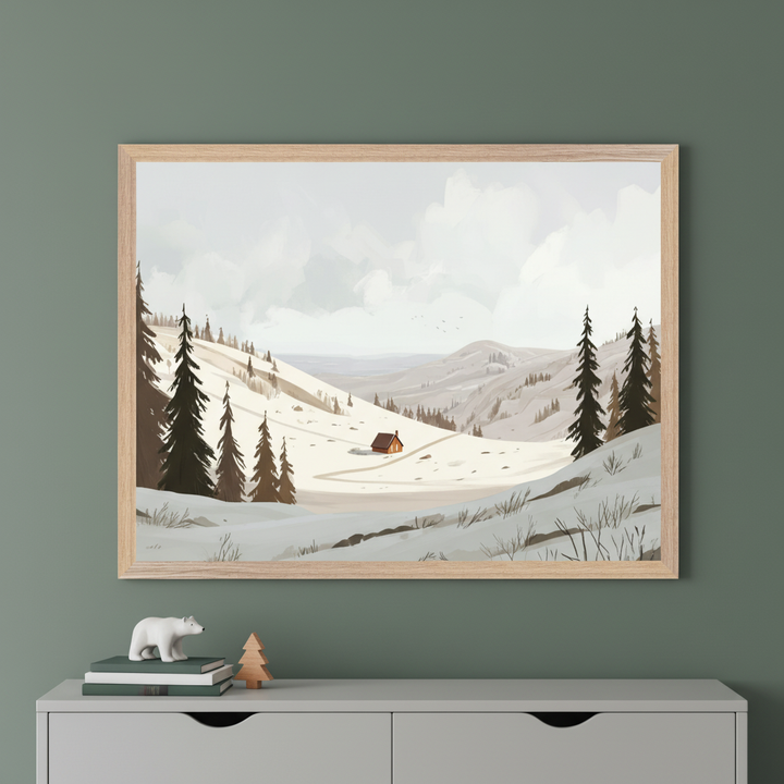Framed artwork depicting a cozy cabin in a snowy mountain landscape, surrounded by evergreen trees under a cloudy sky. The illustration is styled with soft, muted colors and hangs on a green wall above a dresser decorated with a polar bear figurine, stacked books, and a small wooden tree.
