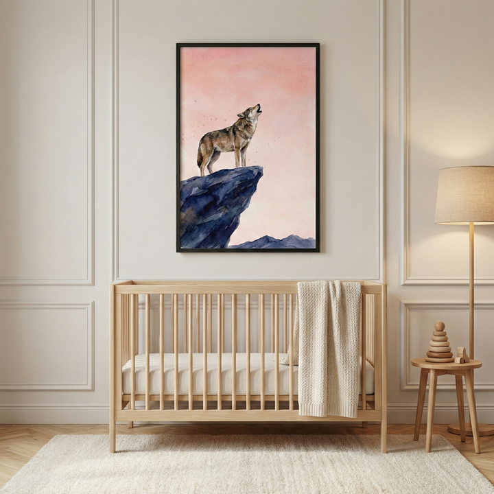 A portrait-oriented framed artwork hangs on a light beige wall featuring decorative panel molding. The art illustrates a brown and grey wolf howling from the edge of a jagged blue cliff under a soft pink sky. Below the art sits a light-toned wooden crib with vertical slats, holding a neutral-colored mattress and a cream knitted blanket draped over the railing. To the right, a simple floor lamp with a neutral shade stands next to a small wooden side table holding a stacked wooden toy.
