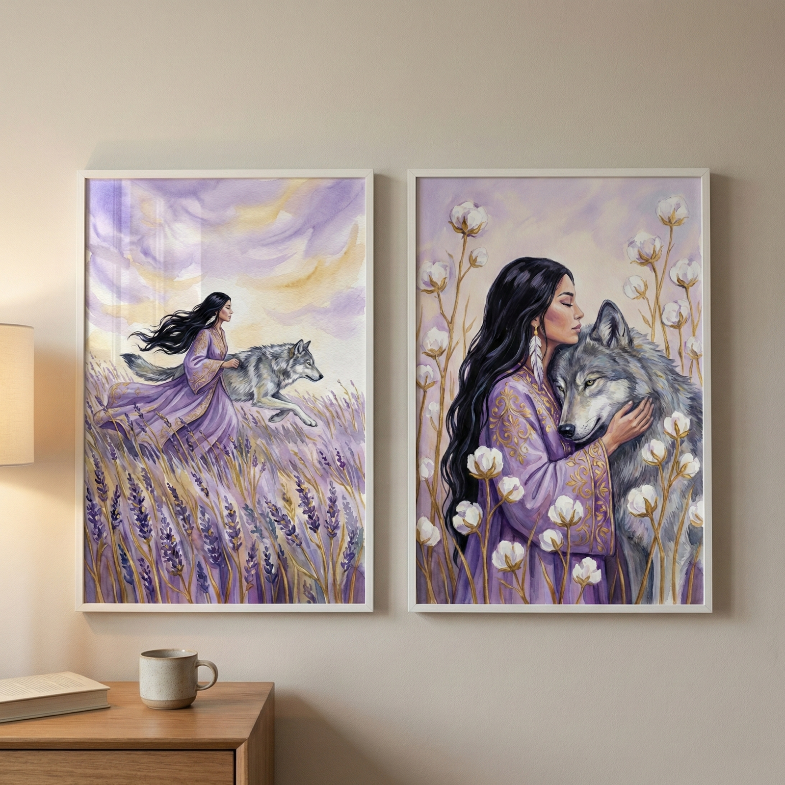 A pair of vertical, white-framed illustrations hangs side-by-side on a neutral-colored wall above a wooden side table. On the table, a lamp casts a warm glow next to a closed book and a simple ceramic mug.

The illustration on the left depicts a woman with long, flowing dark hair and a lavender gown walking through a field of tall purple lavender. Beside her, a large grey wolf moves through the field. The sky above is filled with soft, swirling clouds of purple and pale yellow.


