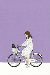 A girl in a white outfit rides a bicycle with a black cat sitting calmly in the front basket. The background is a flat lavender tone, creating a gentle atmosphere.