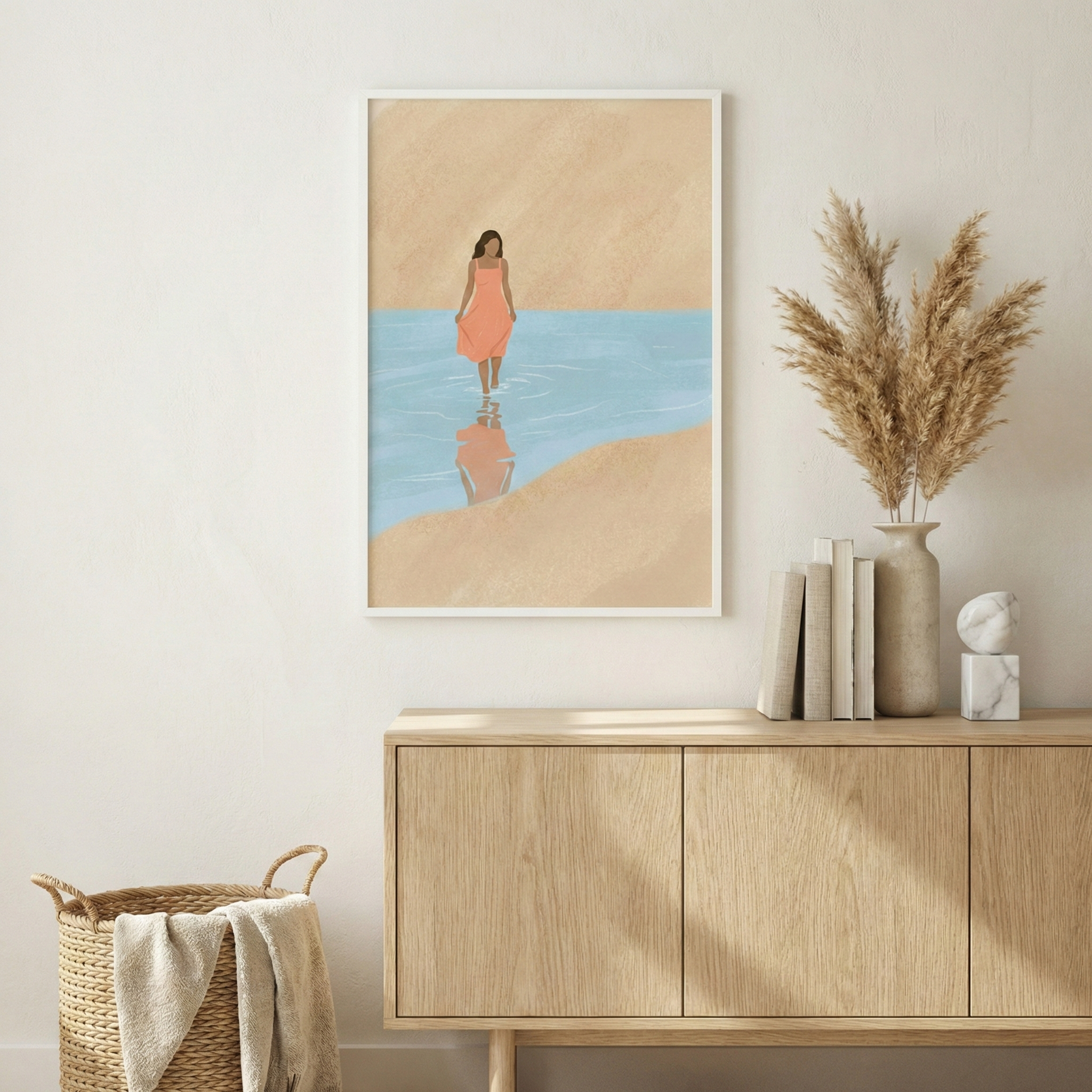 A minimalist framed piece of art is displayed on a textured, light-colored wall. The art depicts a person in a simple coral-toned dress wading through calm, light blue water. The landscape is rendered in large, flat shapes of sand-colored tan. 

