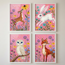 A set of four framed illustrations arranged in a two-by-two grid. Each piece features a different animal against a vibrant pink background filled with colorful wildflowers and splatters. The top-left shows a spotted brown fawn looking up at a yellow flower. The top-right depicts a white rabbit leaping. The bottom-left features a white owl perched on a branch. The bottom-right shows a red fox standing among the blooms. The art style is whimsical and highly detailed.