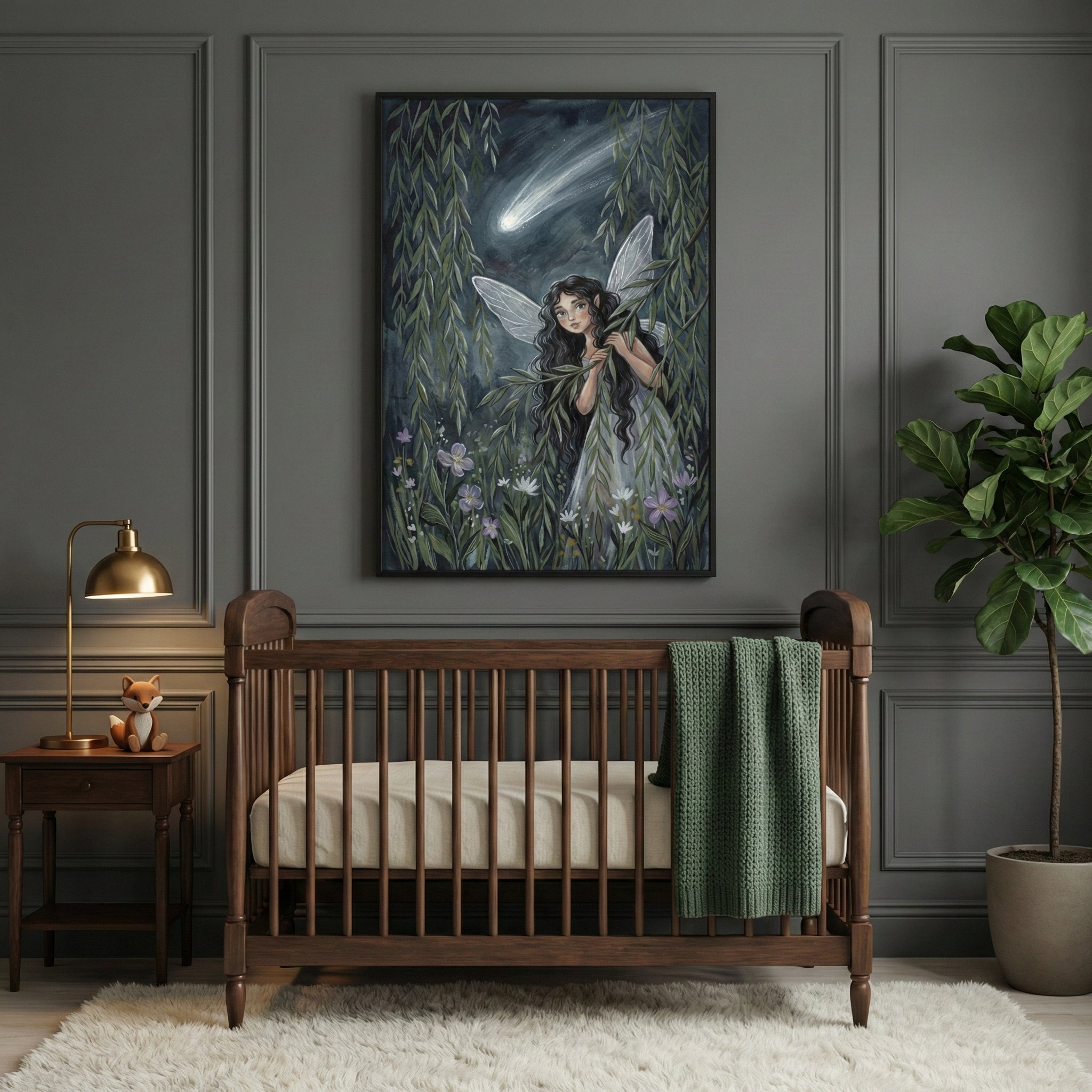 A sophisticated, moody nursery with dark olive-green paneled walls and a classic dark wood crib. Centered above the crib is a large framed vertical artwork depicting a whimsical dark-haired fairy with translucent wings peeking through leafy willow branches under a dark night sky with a bright shooting star. A textured green blanket is draped over the side of the crib. To the left, a small wooden side table holds a gold-colored desk lamp and a tiny fox figurine. To the right, a tall fiddle-leaf fig plant sit