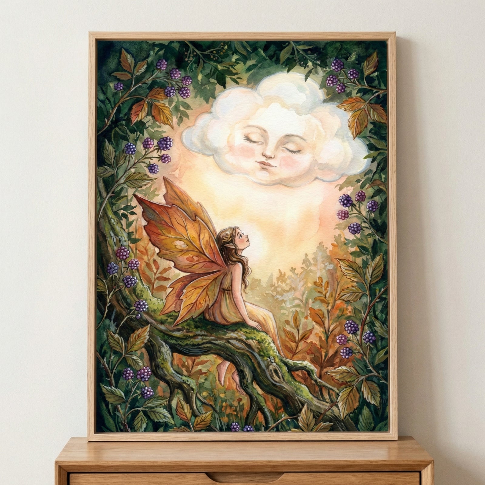 A whimsical watercolor-style illustration of a winged figure with leaf-like wings sitting on a mossy branch, looking up at a cloud with a serene, sleeping face. The scene is framed by dark green leaves and clusters of purple berries, with warm golden light radiating from the center. The art is housed in a light wood frame.