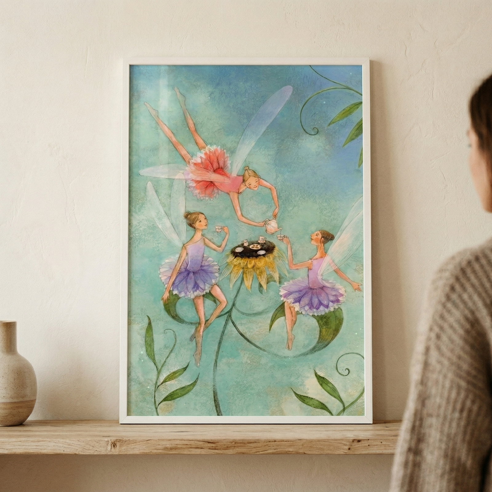 This ethereal illustration depicts three whimsical fairies gathered for a tea party in a magical garden. Against a soft, textured teal backdrop with swirling green stems, the winged figures are dressed in delicate ruffled skirts. One fairy in pink floats above, pouring tea from a small white pot, while two others in purple tutus wait with tiny cups. A large, golden flower serves as a central table for their miniature tea service. 

