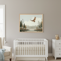 Modern nursery with a white crib. A framed print of a forest lake and flying osprey hangs centered above the crib. A white dresser is to the right, and an armchair to the left.