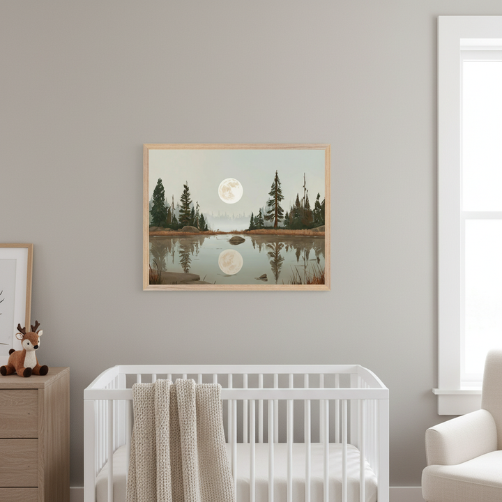 Modern nursery with a white crib and wood dresser. A framed landscape painting depicting a lake with pine trees and a full moon reflecting in the water hangs centered above the crib.