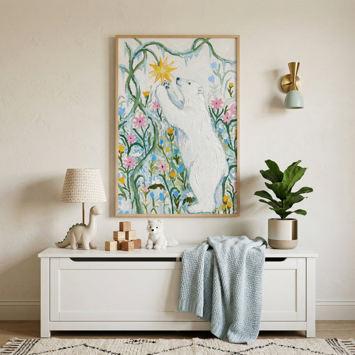 Framed painting of a white bear standing on its hind legs reaching toward a bright yellow star shaped flower among tall green stems and pastel blooms hangs above a white storage bench. Soft nursery decor including a plush toy wooden blocks and a draped blanket creates a calm whimsical space centered around the artwork.