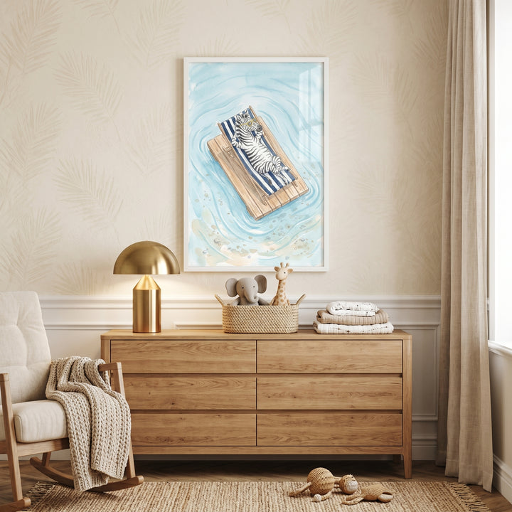 A gold lamp sits on a wooden dresser under yellow sunglasses beach zebra wall art in a light, neutral-toned nursery.