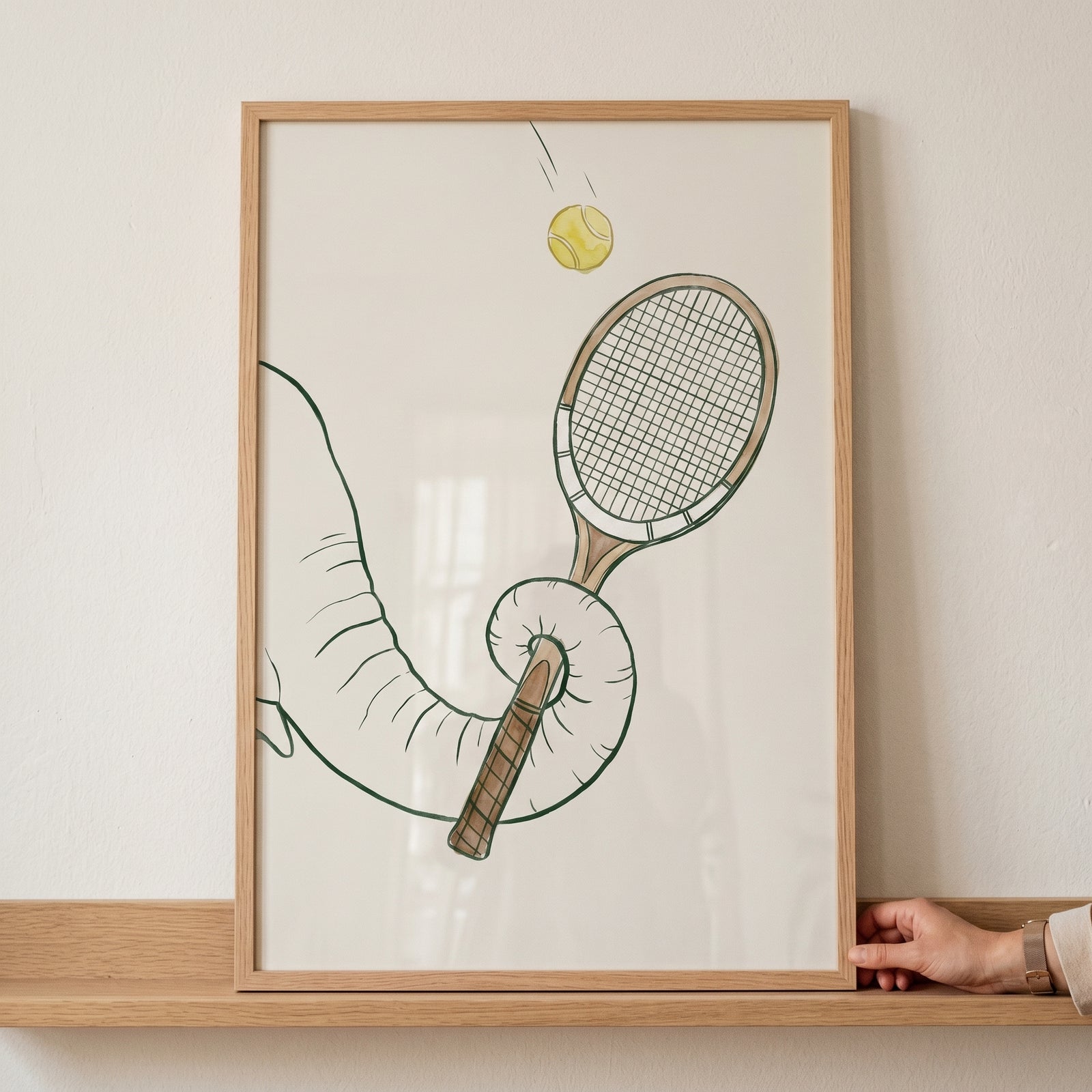 Framed yellow tennis ball elephant print featuring an elephant trunk holding a tennis racket with a ball in the air.